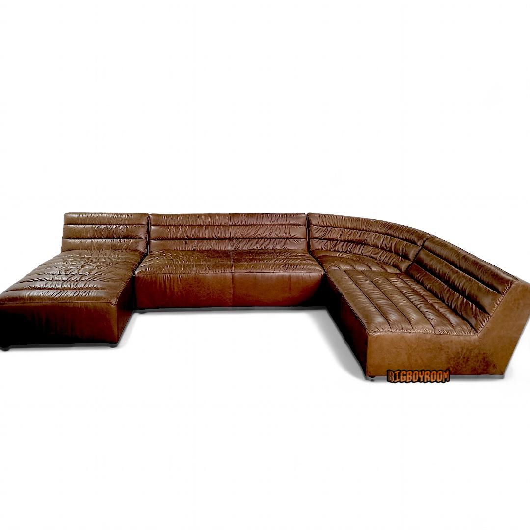 Hughes 模組化皮沙發：低重心雕塑輪廓與連續車縫，可 L 型或馬蹄形拼組