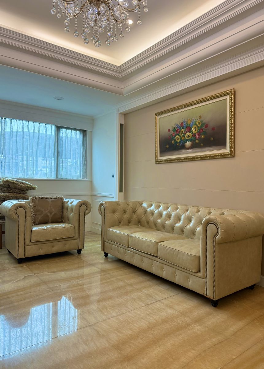 客製化 Chesterfield 經典英倫沙發｜台北大安區信義華府私宅，杏色大理石紋全牛皮三人座與單人座沙發配置實景。