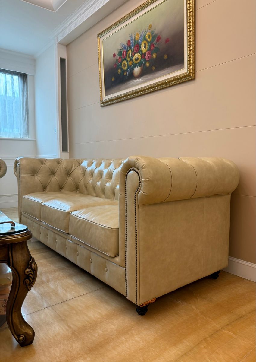 英倫復古牛皮沙發工藝細節｜Chesterfield Style B 系列三人沙發側拍，展現經典深拉扣背靠與復古銅釘捲曲扶手設計。