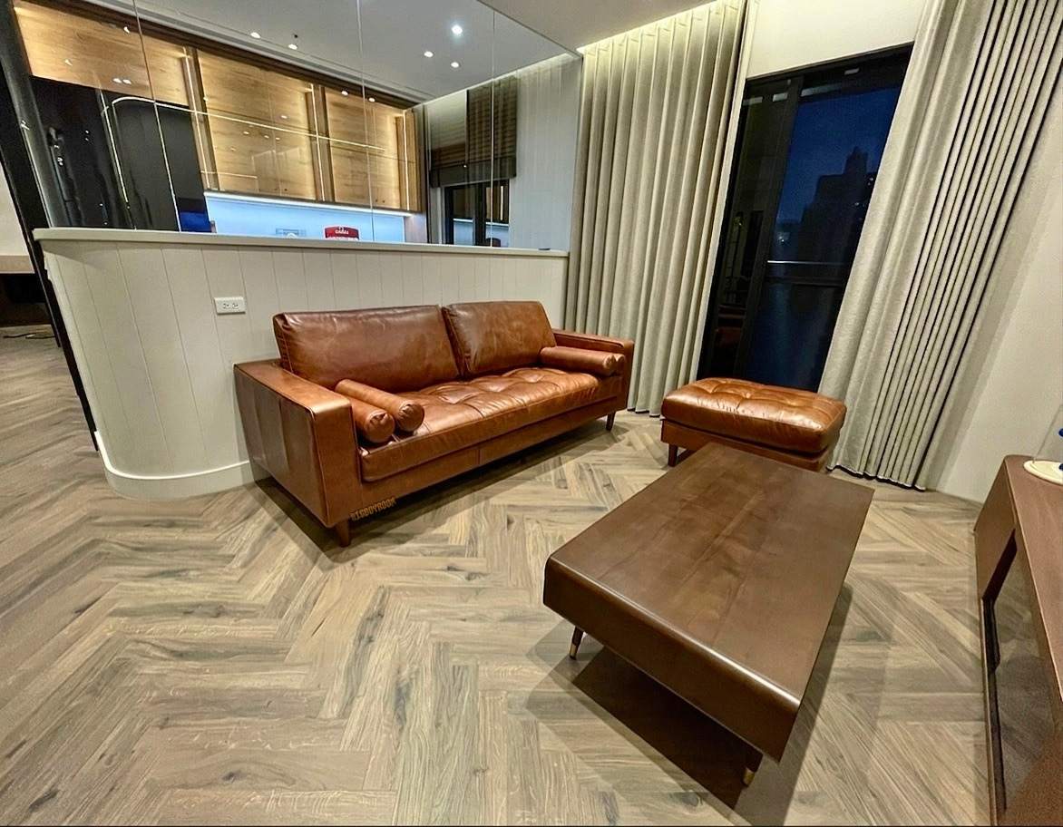 BigBoyRoom 客製家具板橋案例，Thomas 美式全牛皮沙發搭配木質茶几，復古棕色皮革與白色半高牆形成優雅對比，後方玻璃展示櫃完美突顯屋主的藏家品味。
